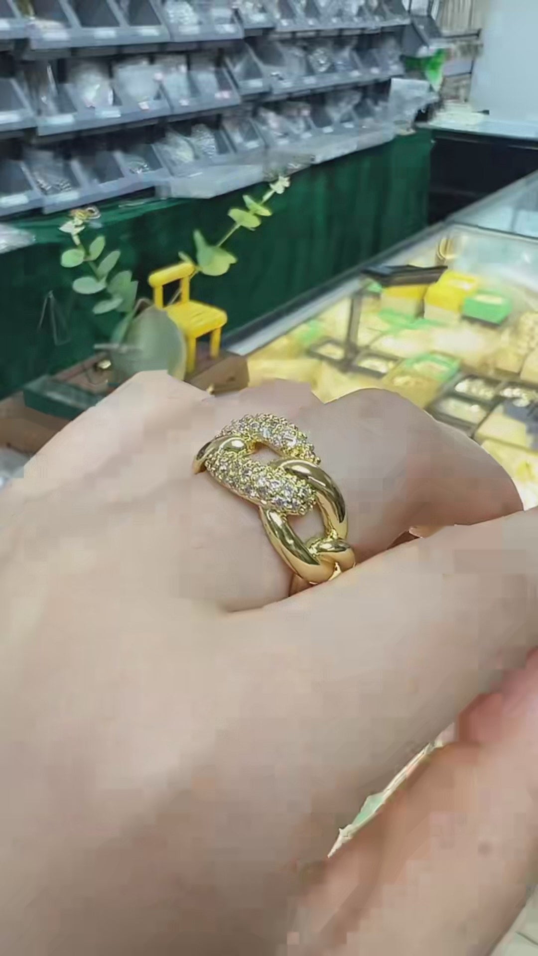  18K gold-plated Jasmine ring on a finger, rotating to reveal its unique interlocking Cuban chain knot design. The ring features a stunning contrast between a high-shine smooth gold surface and a brilliant micro-pave crystal setting that sparklingly catches the light. This video answers how to choose a tarnish-resistant statement ring for everyday luxury, providing aesthetic style inspiration for standard office wear, street chic layers, and timeless minimalist capsule wardrobes.
