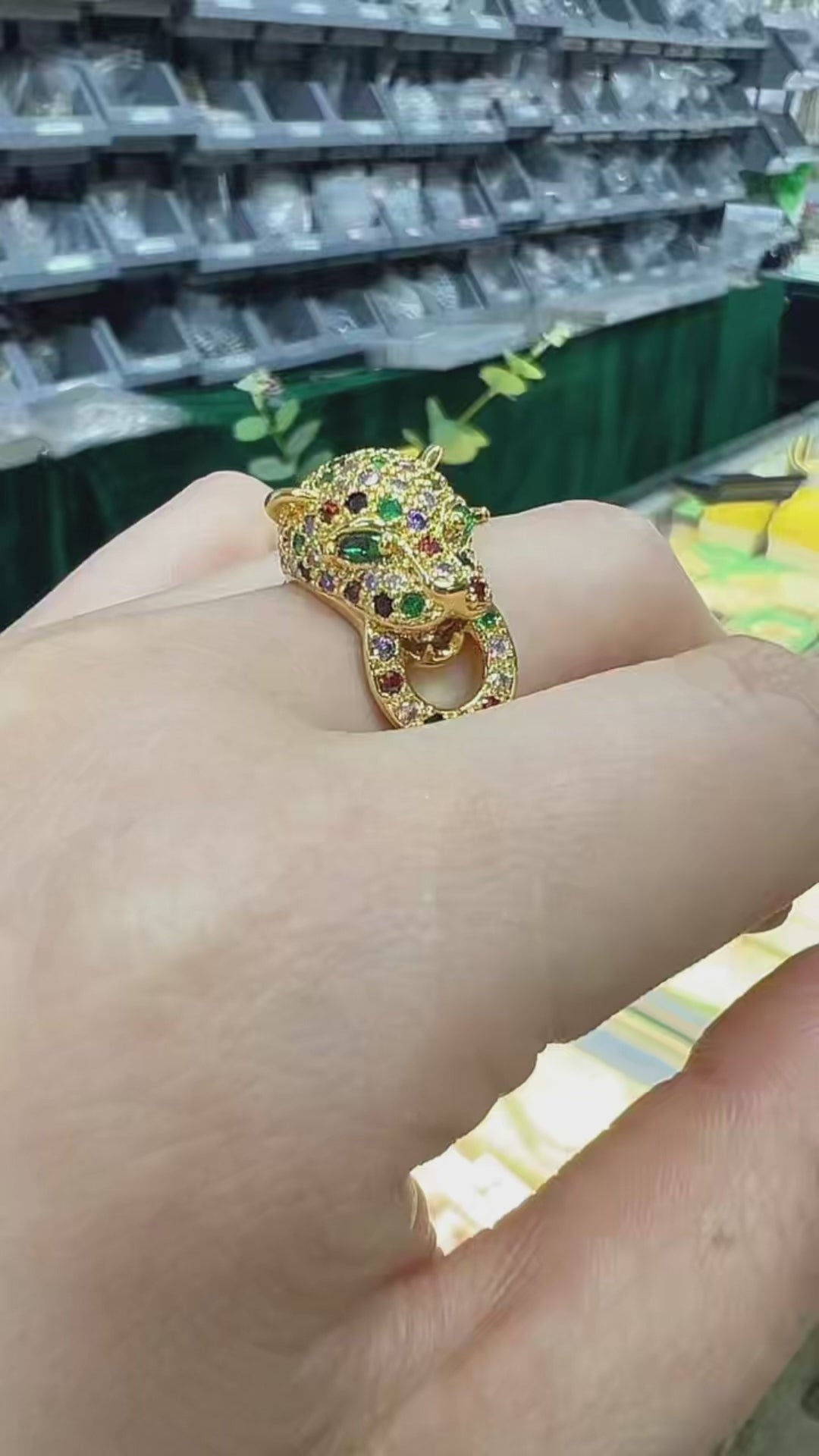 Showcasing a luxury 18K gold-plated Jaguar ring being worn and rotated on a finger to display its intricate multi-color crystal micro-pave setting. The 3D sculptural panther head features sparkling green gemstone eyes and a vibrant mix of red, purple, and yellow crystals that brilliantly catch the light. This video answers how to choose a bold statement ring for evening wear, providing inspiration for the mob wife aesthetic, vintage cocktail jewelry, and unique luxury holiday gift ideas for her.