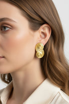 Side profile view of Seraphina small sculptural gold earrings, showcasing the unique swirl design and premium 18K gold plating.