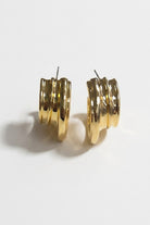 Pair of triple-ribbed wave hoop earrings on a white background