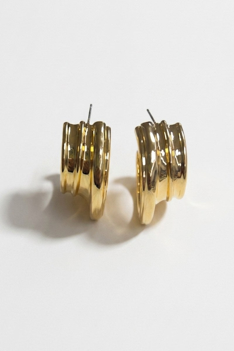Pair of triple-ribbed wave hoop earrings on a white background