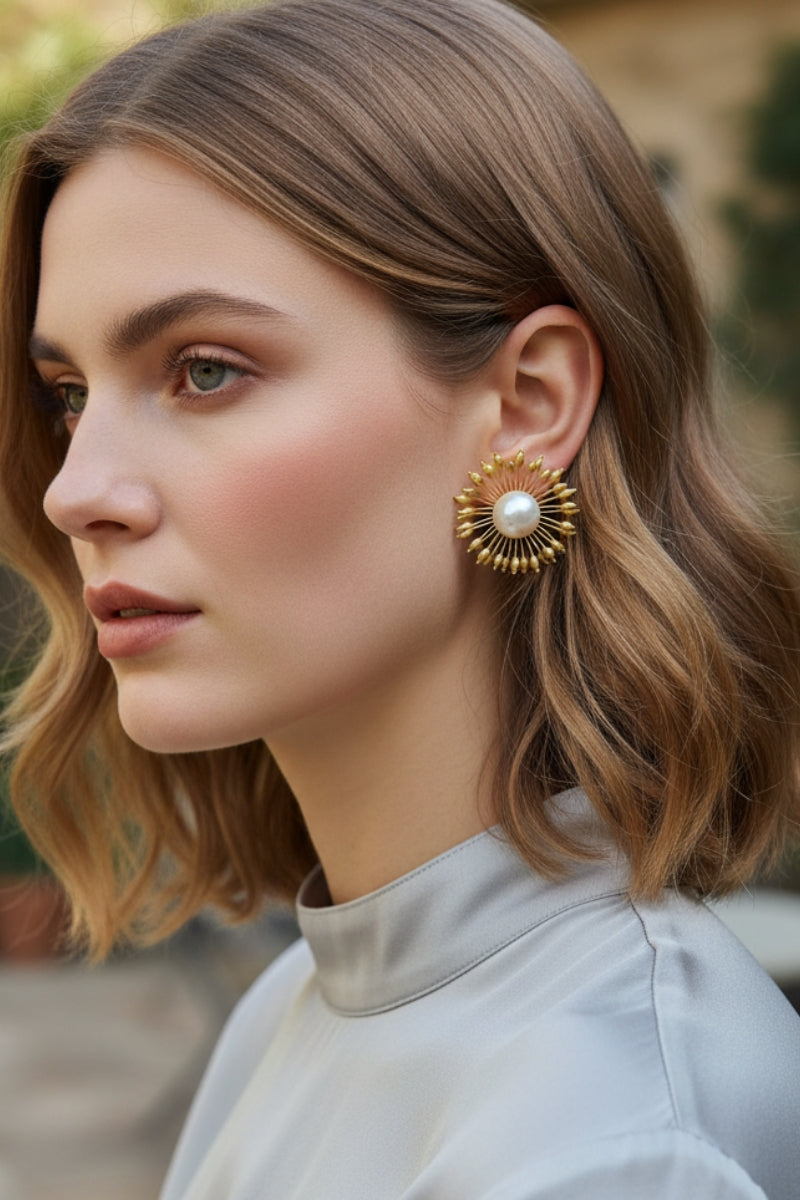 Elegant woman wearing sunburst pearl statement earrings at a sunset outdoor wedding, ideal for bridal party style.