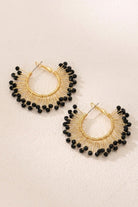 Solburst wire-wrapped beaded sunburst hoop earrings in the Noir variant on a warm beige background
