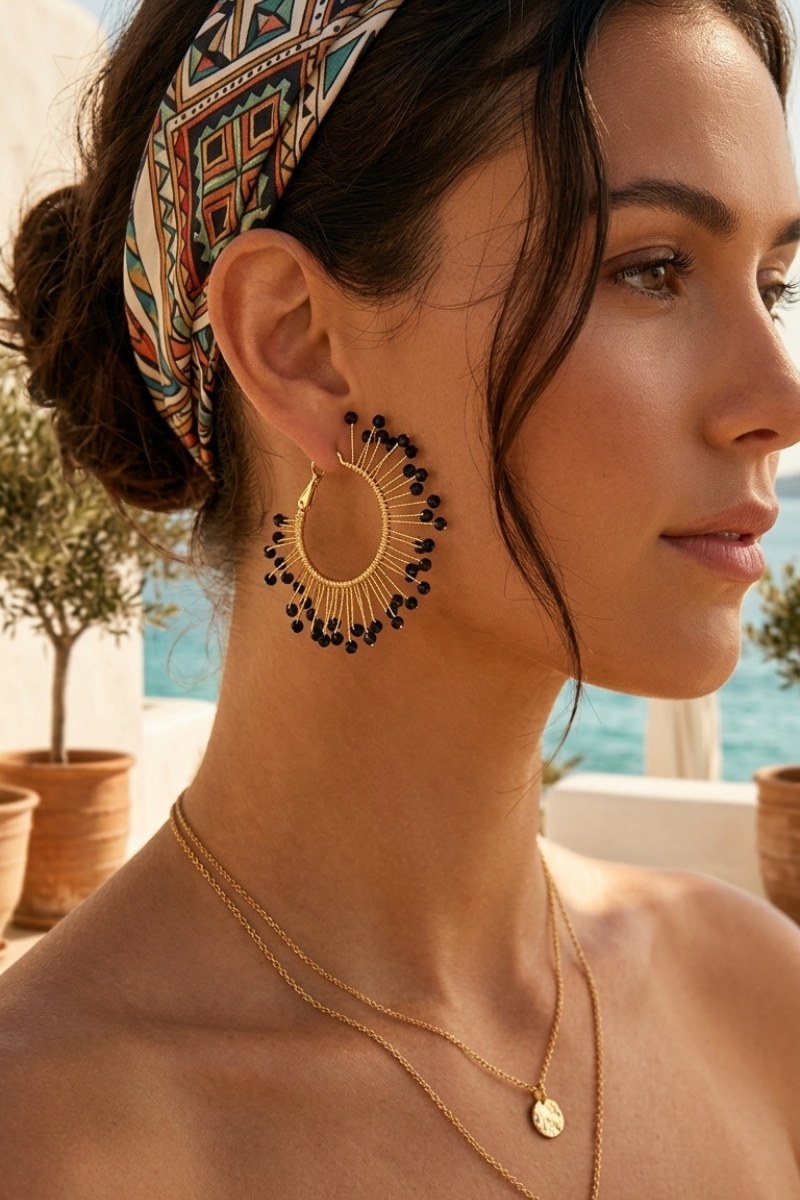 Model wearing solburst wire-wrapped beaded sunburst hoop earrings in the Noir variant, view 3