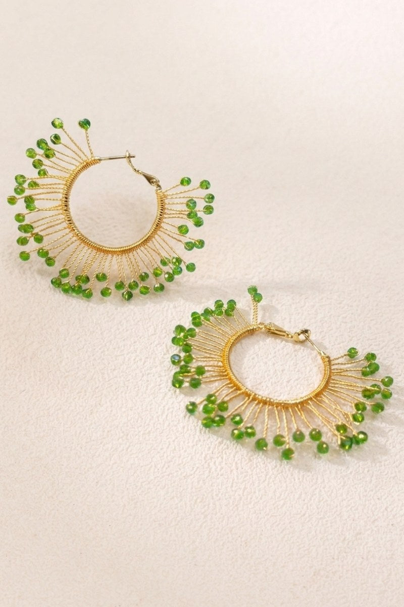 Solburst wire-wrapped beaded sunburst hoop earrings in the Olive variant on a warm beige background
