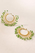 Solburst wire-wrapped beaded sunburst hoop earrings in the Olive variant on a warm beige background