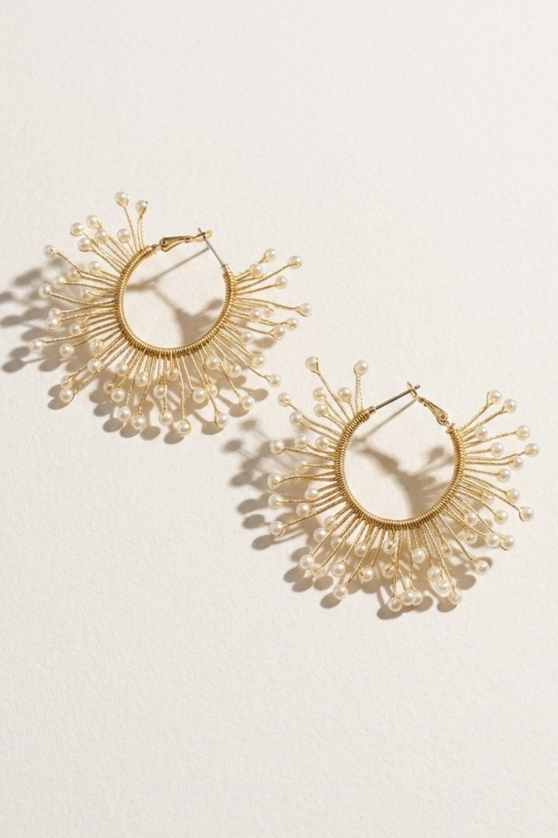 Solburst wire-wrapped beaded sunburst hoop earrings in the Pearl variant on a warm beige background