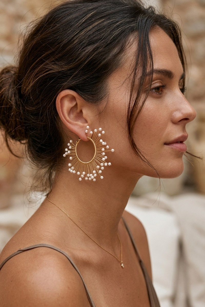 Model wearing solburst wire-wrapped beaded sunburst hoop earrings in the Pearl variant, view 3