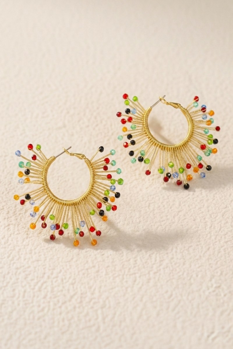 Solburst wire-wrapped beaded sunburst hoop earrings in the Prism variant on a warm beige background