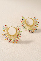 Solburst wire-wrapped beaded sunburst hoop earrings in the Prism variant on a warm beige background