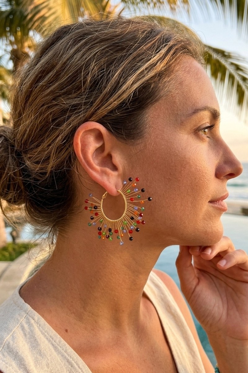 Model wearing solburst wire-wrapped beaded sunburst hoop earrings in the Prism variant, view 2