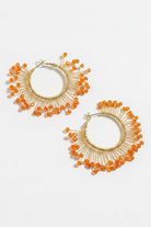 Pair of solburst wire-wrapped beaded sunburst hoop earrings in the Tangerine variant on a white background